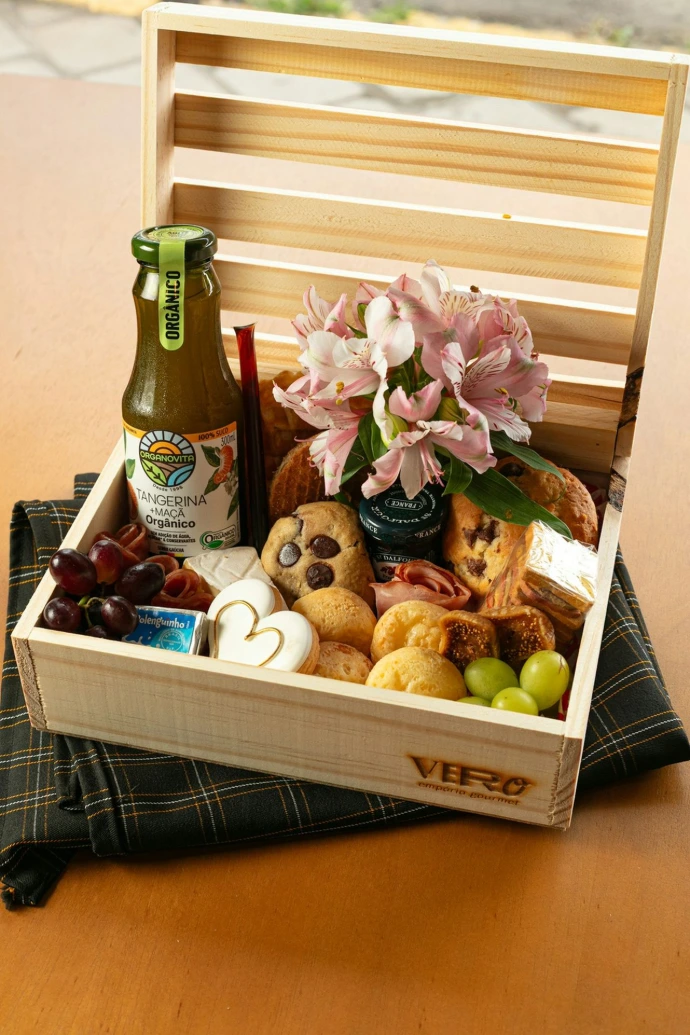 Wooden crate filled with food, flowers, and drink